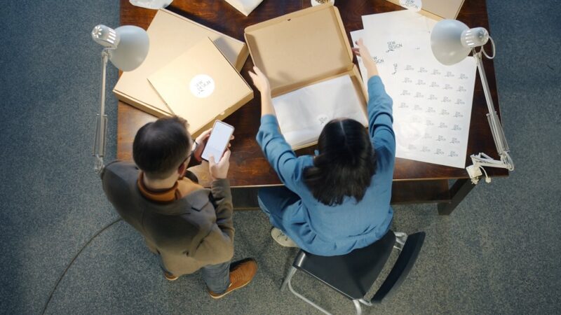 Overhead view of a structured packing station where inventory is inspected and organized before shipment